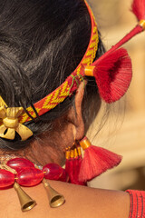 Selective focus close up Macro image of a traditional tribal red earring and headgear worn by a...