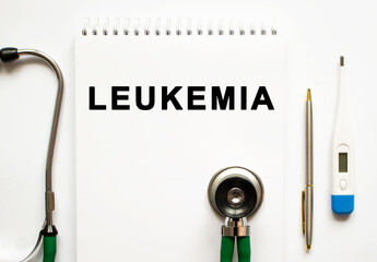 LEUKEMIA text written in a notebook lying on a desk and a stethoscope.
