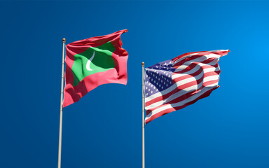 Beautiful national state flags of Maldives and USA together at the sky background. 3D artwork concept.