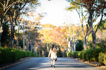 秋の公園で遊ぶ少女