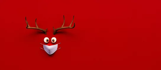 Rentierspielzeug mit kalter roter Nase und medizinischer Maske auf rotem Weihnachts-Corona-Hintergrund 3D-Rendering © hd3dsh
