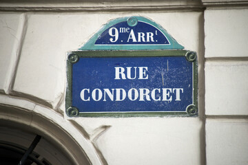 Closeup of Condorcet street name on the traditional parisian street plate on stoned building 