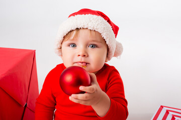 Cute baby Santa with gift boxes smiling against a white background. the concept of Christmas. Space for text