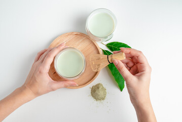 Girl holding mug of Matcha green Tea in her hands. Organic green tea leaf isolated on white background, Organic product from the nature for healthy with traditional style