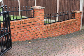 UK domestic brick wall with black railings
