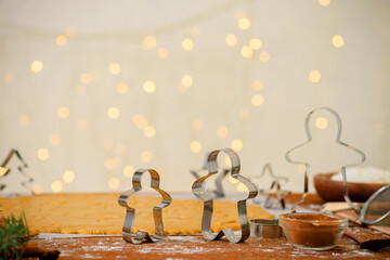 forms for gingerbread Christmas men and stars, close-up, top view, raw dough with cinnamon prepared for baking .