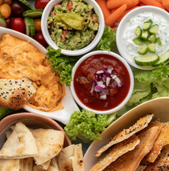 Top down view of various appetizer dips ready for snacking.