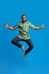 Emotional black guy showing happiness on blue background