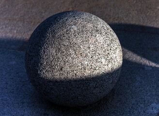 Granite ball close-up on the pavement in summer