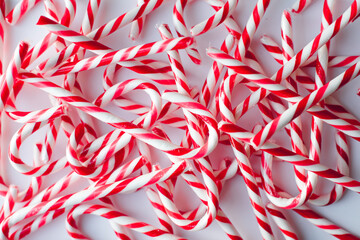 Close up of many candy canes against a plain white background.
