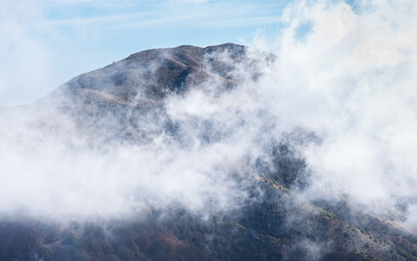 Naklejka na ściany i meble White clouds wrap around spectacular mountain Paggaio. Greece