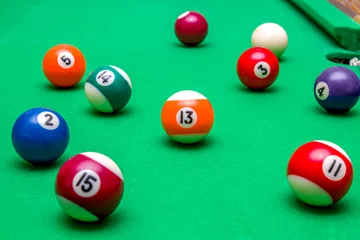 Foto op Plexiglas Sports game of billiards on a green cloth. Multi-colored billiard balls with numbers on a pool table. Active leisure and entertainment. Billiards. Billiard balls close-up. © kvdkz
