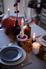 Table serving. Autumn mood, candles, pumpkins, apples. Cozy atmosphere, interior decor. Thanksgiving, halloween