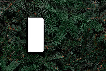 Mock up. Smart phone on Christmas tree branches. Top view, flat lay, copy space. Nature New Year holiday concept. Pine, fir pattern. Christmas shopping online. Mobile app