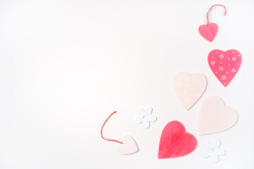 Pink and white hearts of different sizes are laid out on a light background in the right part of the frame. Top view with space to copy. The Concept Of Valentine's Day.