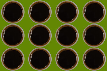 pattern with cups of black espresso coffee on green, pepper stem pantone color background