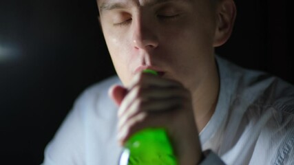 Young man eating chips and drinking beer late at night
