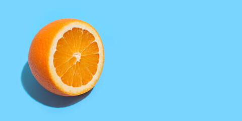 Ripe juicy delicious orange on blue background. Healthy eating and dieting concept
