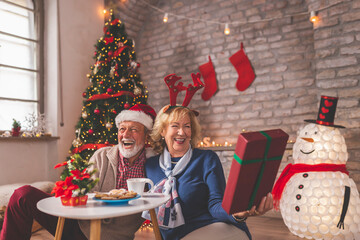 Obraz na płótnie Canvas Senior couple exchanging Christmas presents