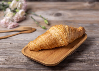 tasty croissants in a wood plate on dark wooden table, closeup. French pastry