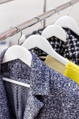 Jackets hanging on wooden clothes hangers in a modern clothing store, shop, mall, market, showroom. Fashion collection. Personal stylist, sales, shopping. Dressing room. Retail
