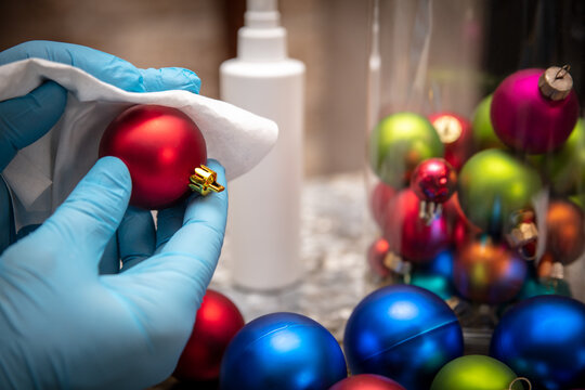 Man disinfecting christmas balls or baubles in days of the corona pandemic, hygienic