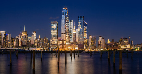 Fototapeta na wymiar New York City evening panoramic of Manhattan Midtown West skyline with illuminated Hudson Yards skyscrapers from the Hudson River. NYC, USA