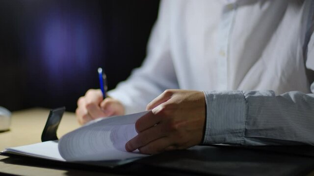 Boss signs documents late at night in the office