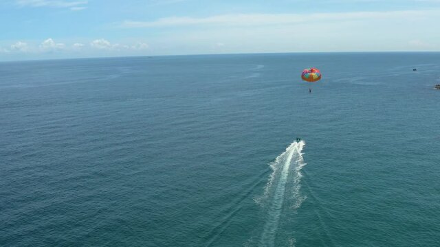 Parasailing water amusement. Flying on a parachute behind a boat on a summer holiday by the sea in Ky Co beach, Quy Nhon, Vietnam. Travel and sport concept.