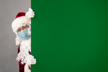 Senior man wearing Santa Claus costume and protective mask