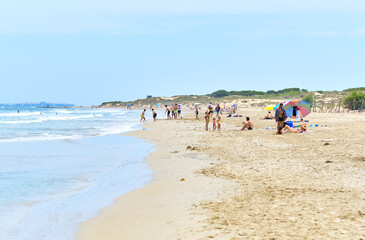 People on the sandy beach of Los Arenales del Sol, Spain