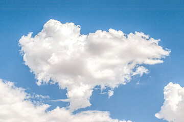 Fototapeta na wymiar Single white cloud in a shape like a circle against beautiful blue sky in the centre of the image