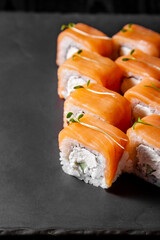 Vertical frame, set of 8 philadelphia rolls on black stone board