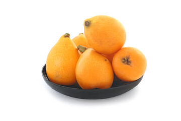 Loquats on wood plate isolated on white