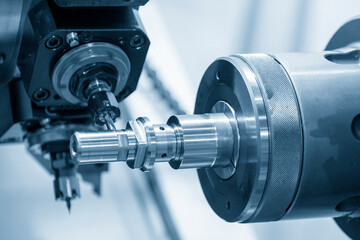 The operation of turn-mill machine slot cutting on the metal shaft parts. The hi-technology automotive part manufacturing process by CNC multi-tasking machine. © Pixel_B