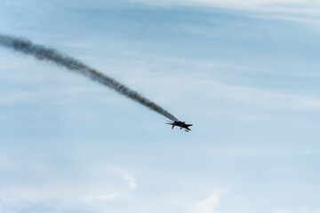 Military fighter jet during a fall on background of blue sky. The plane was shot down in combat....