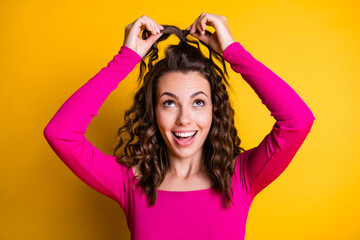 Obraz na płótnie Canvas Photo portrait of woman making silly ponytail smiling wearing pink crop-top isolated on bright yellow colored background