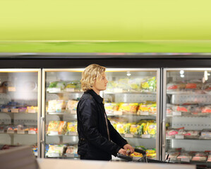 Fototapeta na wymiar Man choosing frozen food from a supermarket freezer