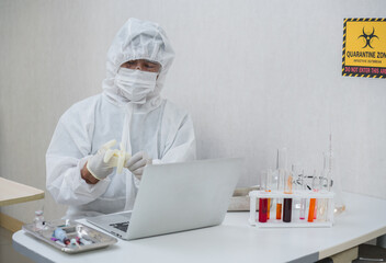 Medical laboratory technician wearing surgical medical gloves to prepare test analysis.Covid-19 infectious disease in the laboratory Quarantine Zone.