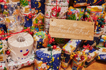 Wrapped gifts that are part of an advent calendar. The text on the sign is German for Happy Holiday.