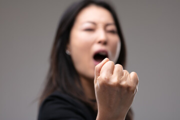 Asian woman threatening with her fist