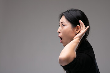 Asian woman eavesdropping reacting in shock