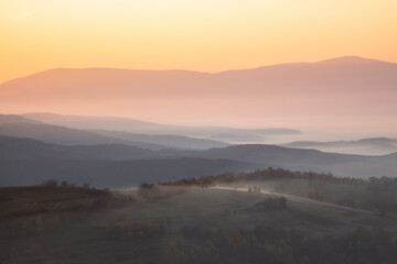 dawn cream mountains in the fog. Climate change from summer to autumn.