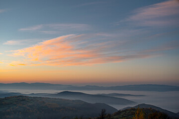 dawn cream mountains in the fog the sky shimmers with beautiful colors. Climate change from summer to autumn.