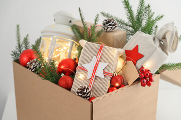 Christmas gifts in eco-friendly reusable packaging and decorations in a cardboard box. Delivery and...