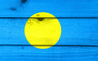 Palau flag painted on old wood plank background. Brushed natural light knotted wooden board texture. Wooden texture background flag of Palau