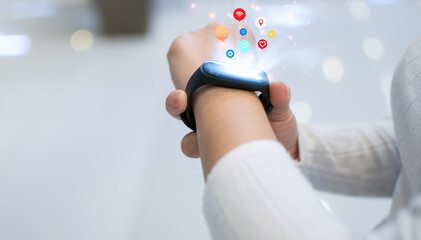 Woman is setting up a smart watch for use innovative technology. Mixed media, digital..