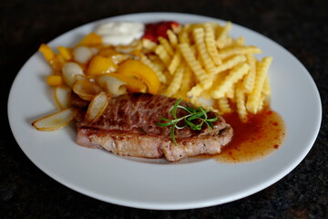roasted steak with french fries and paprika