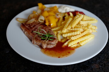 roasted steak with french fries and paprika