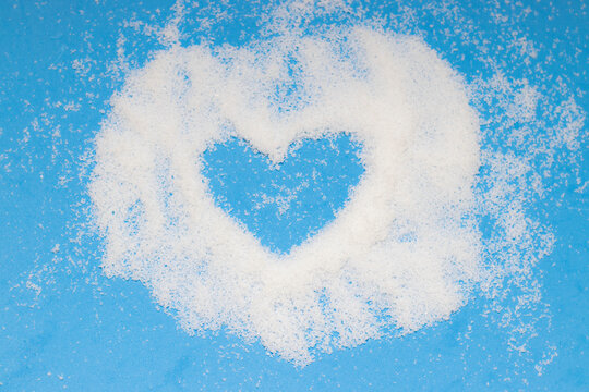 Silhouette of a heart in the snow on a blue background. For New Year and Christmas designs. A photo